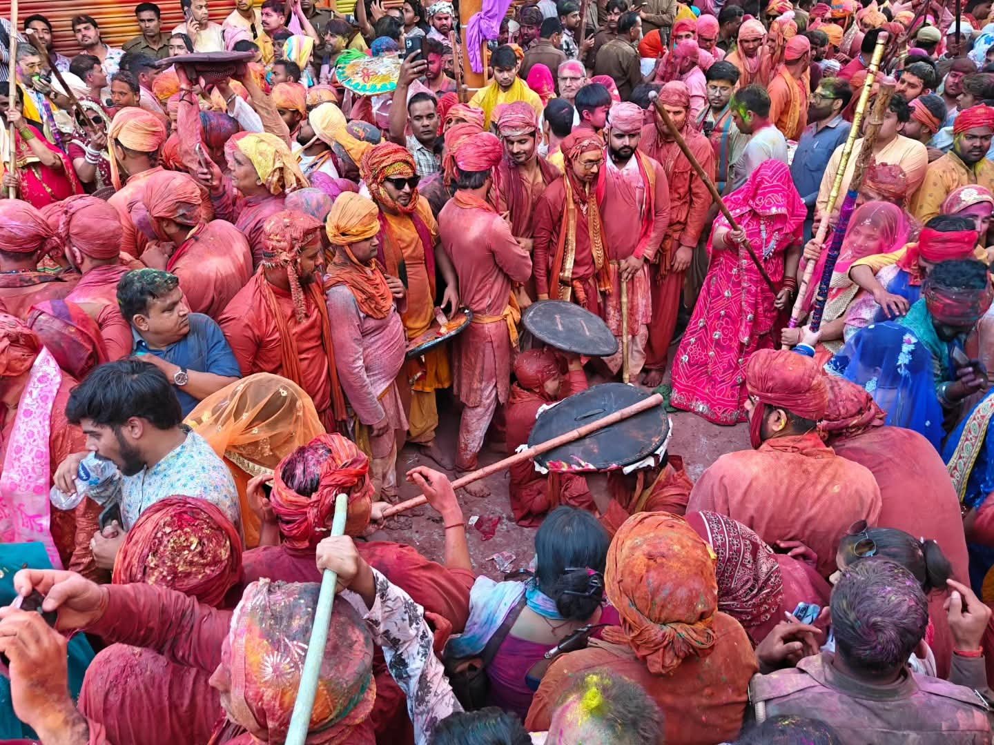 Barsana Lathmar Holi 2026, women hitting huriyares with sticks, huriyares using shields, vibrant colors and gulal, traditional Holi celebration in Braj, India