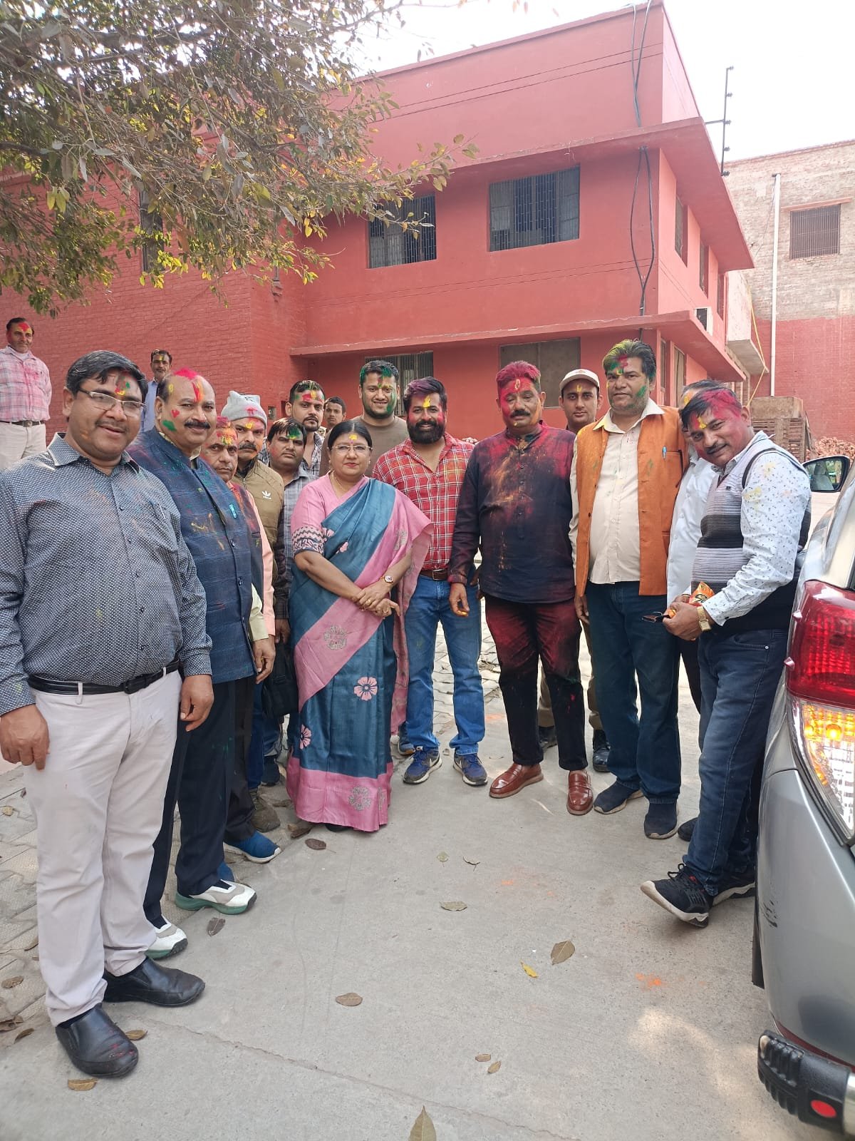 University staff celebrating Holi together in Agra, showing unity, enthusiasm and colors, staff exchanging gulal and flowers during the Holi Milan ceremony