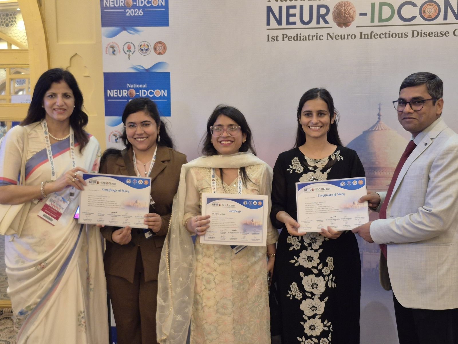 “Junior residents of Sarojini Naidu Medical College, Agra receiving awards at NEURO IDCON 2026 for oral and poster paper presentations on pediatric Tuberculous Meningitis and Acute Gastroenteritis research.”