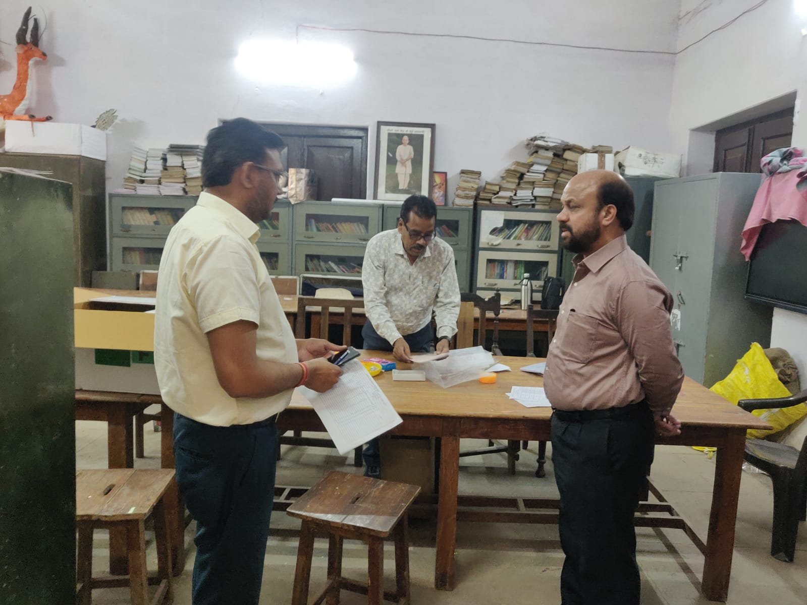 Examiners checking answer sheets at Agra evaluation centers on the first day, highlighting delayed attendance and limited answer sheet evaluation