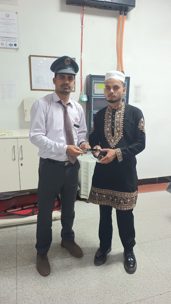 Agra Metro staff returning a lost mobile phone to a passenger at the metro station through the lost and found cell with verification and security procedures.