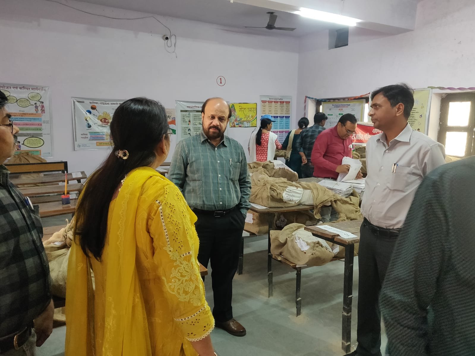 Evaluation of answer sheets in Agra Mandal with teachers checking copies and administrative monitoring