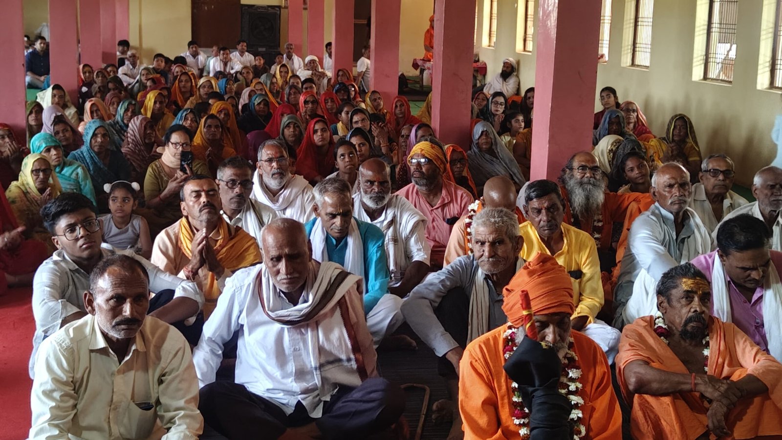 Devotees sitting and attentively listening to the Srimad Bhagavat Katha, immersed in spiritual storytelling, Indian temple religious gathering, faith and devotion visual for news and blogs