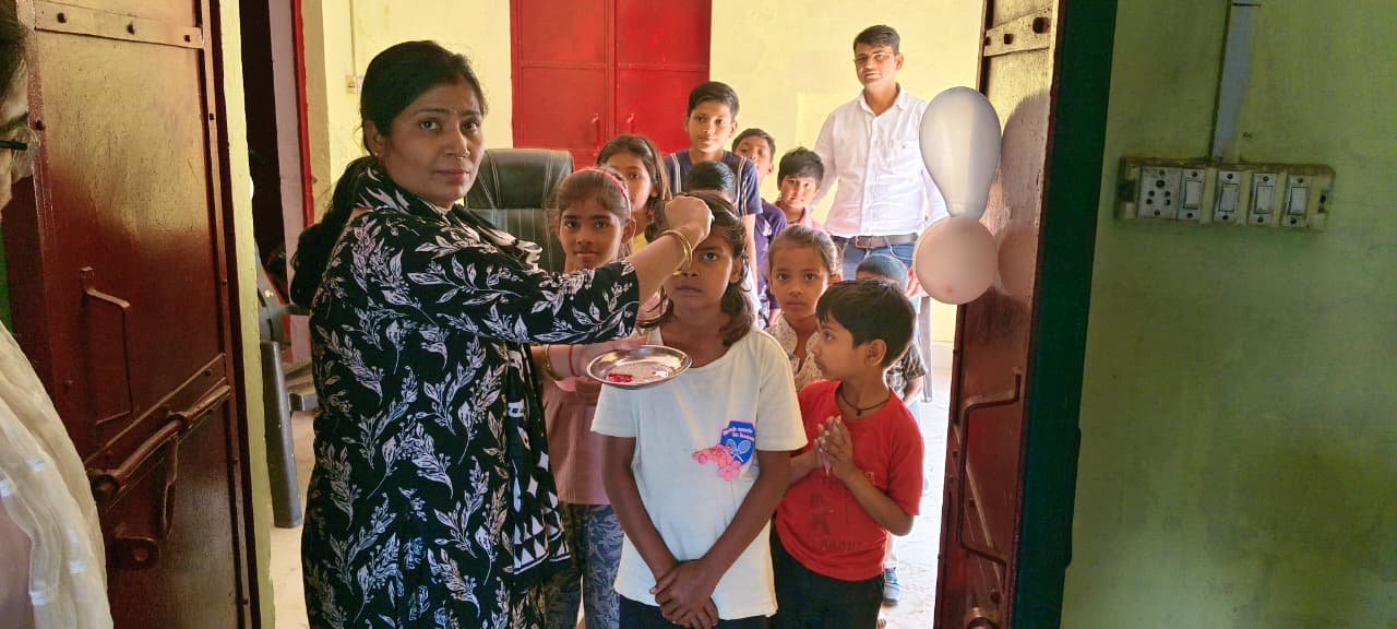 Teachers distributing textbooks to students during School Chalo Abhiyan in Fatehabad, awareness rally led by Block Education Officer.