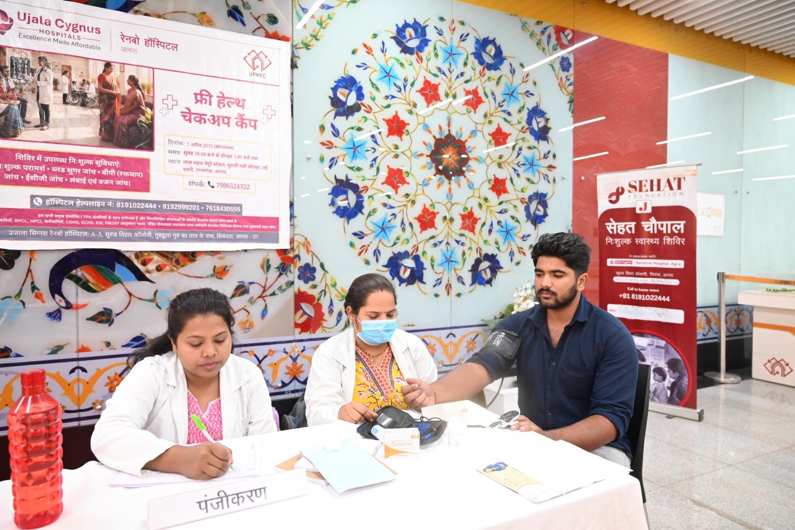 Doctors conducting free health checkup including blood pressure and sugar test at Taj Mahal Metro Station on World Health Day in Agra