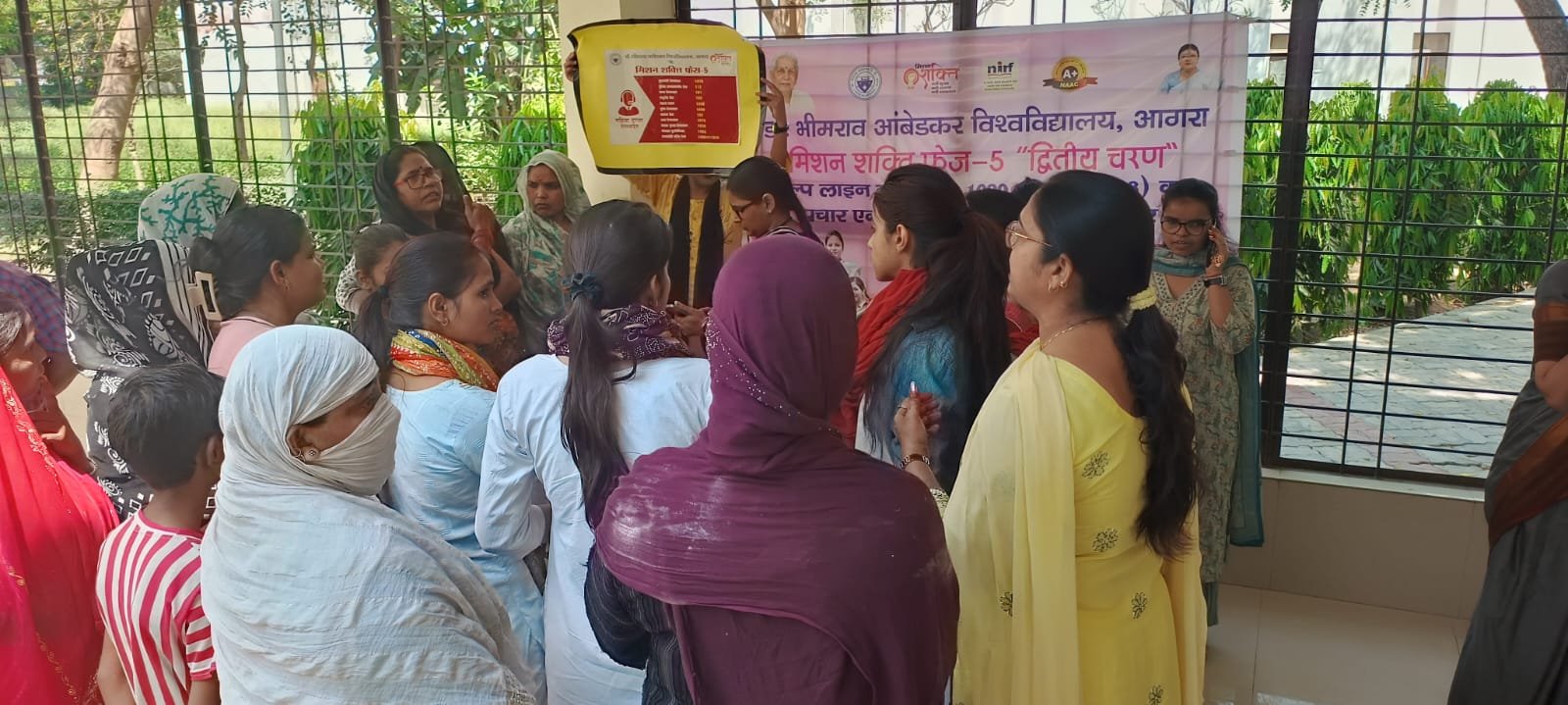 Women attending the Mission Shakti Phase-5 awareness program at Dr. Bhimrao Ambedkar University, Agra, focusing on women's safety, rights, and helpline services.