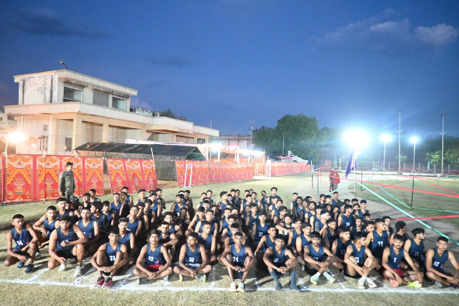 Candidates participating in the Agniveer recruitment rally at Eklavya Sports Stadium, Agra, with proper arrangements for physical fitness tests, medical screening, and safety measures.