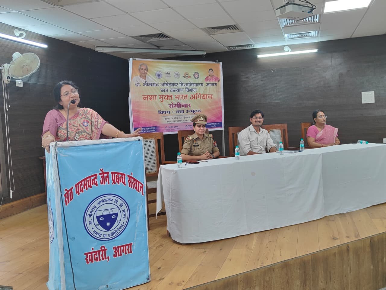Students participating in the Nasha Mukt seminar, creative posters displayed in the Lalit Kala Institute, group pledge for a drug-free society, Vimal Sahu delivering speech on substance abuse awareness, poster exhibition showcasing students’ awareness messages