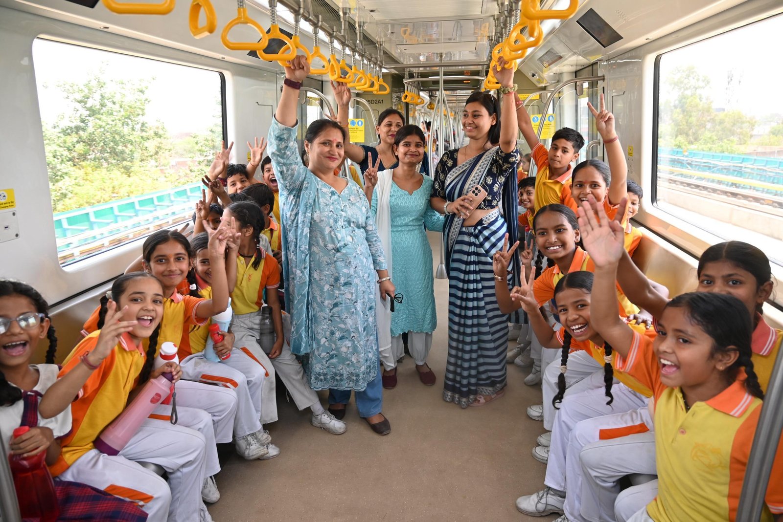 Students of Dr. Bhimrao Ambedkar University and RBPS Kids Paradise School participating in Agra Metro World Heritage Day celebration with rangoli at Dr. Ambedkar Chowk Metro Station and metro ride experience