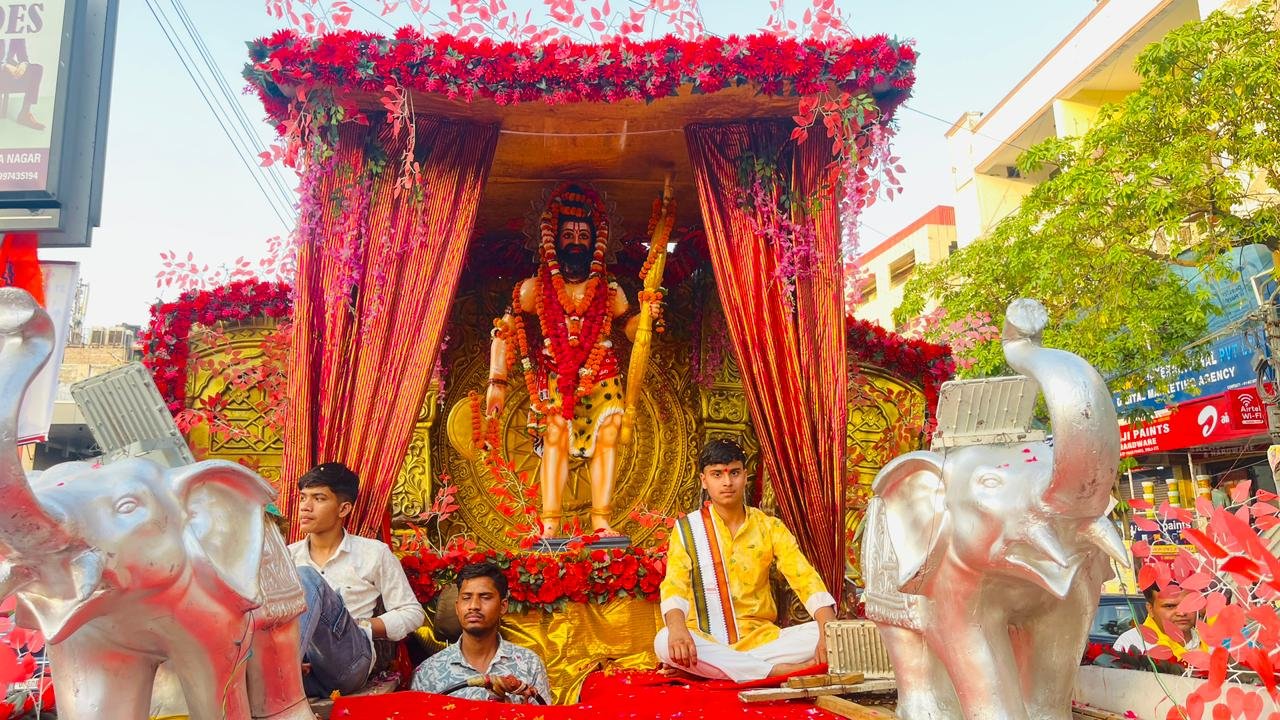 A grand procession of Lord Parshuram Shobha Yatra in the Awas Vikas Colony area of Agra featuring 31 beautifully decorated tableaux, devotees participating in large numbers, cultural and religious displays, and a massive Maha Aarti with 1108 oil lamps at Parshuram Chowk creating a vibrant and devotional atmosphere.