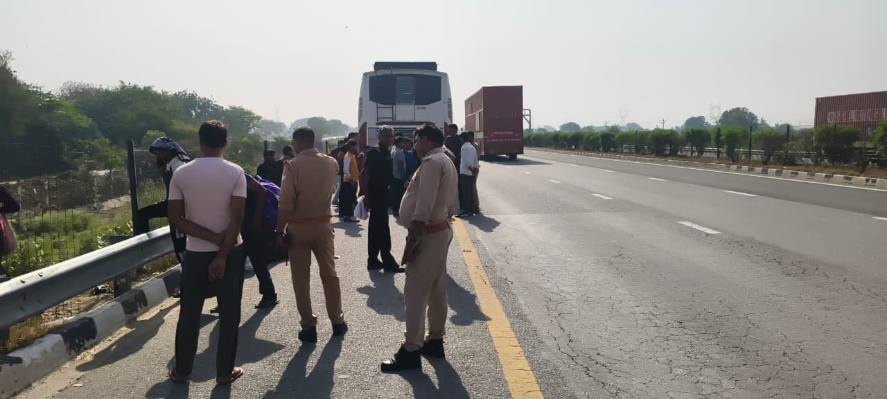 Passengers standing on Agra Lucknow Expressway in Fatehabad after bus accident caused by tyre burst and collision with divider