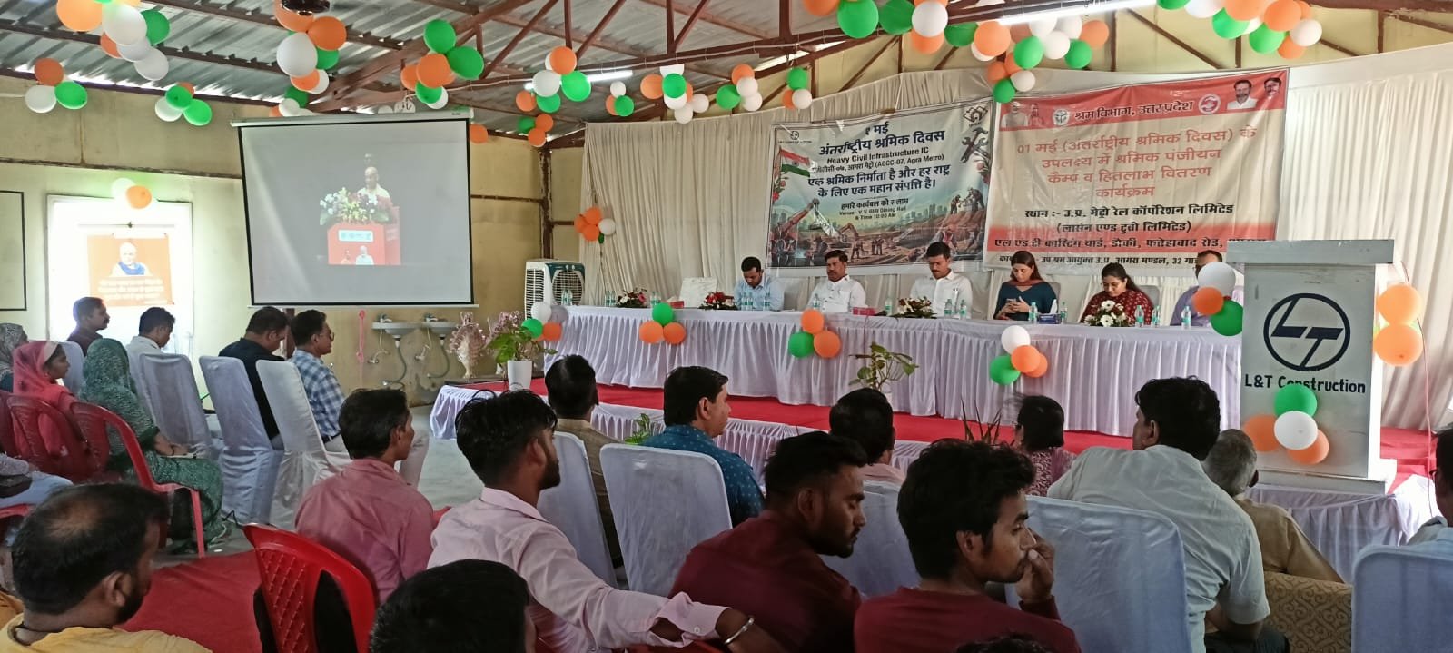 Labour Day event in Agra where workers are receiving government scheme benefits and assistance during a felicitation program