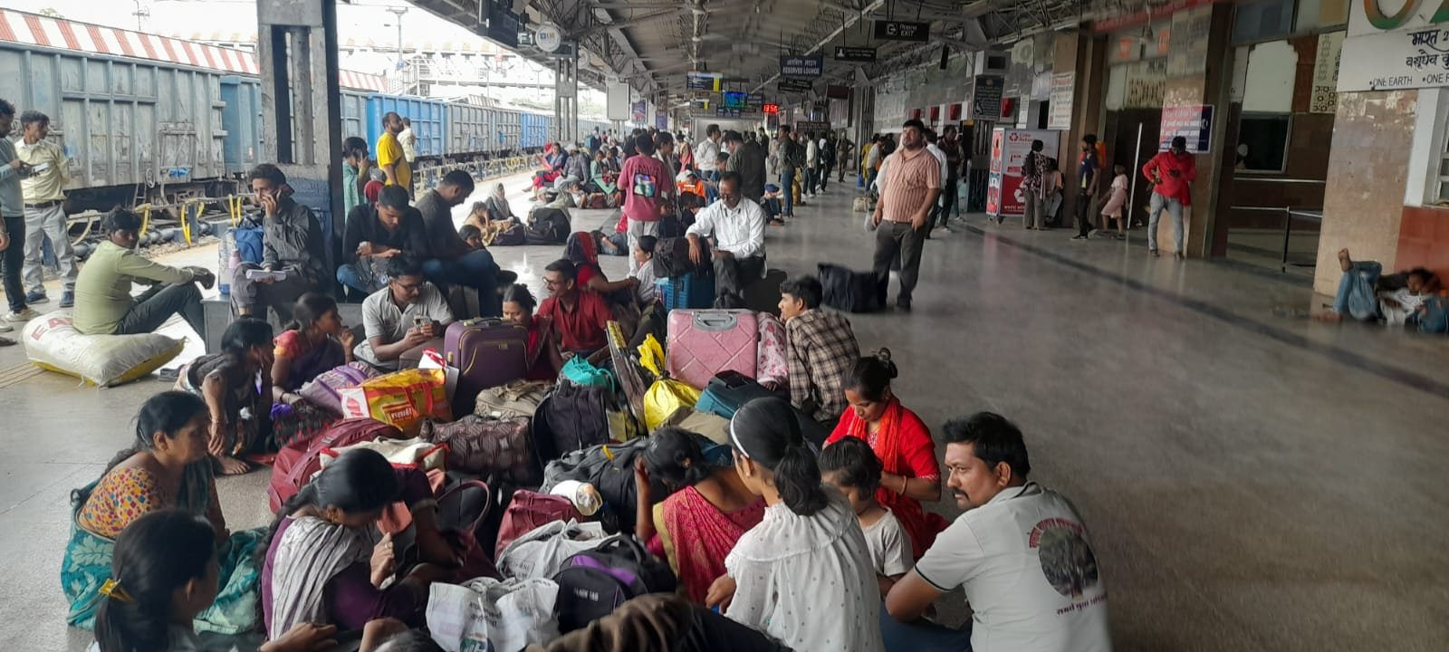 Huge crowd of passengers waiting at railway station as trains show no room availability before summer holidays