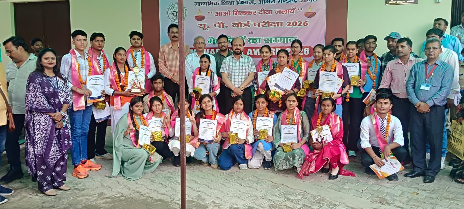 Meritorious students receiving Exam Warrior Award 2026 from Joint Director Dr Mukesh Chandra Agrawal with teachers present in Agra