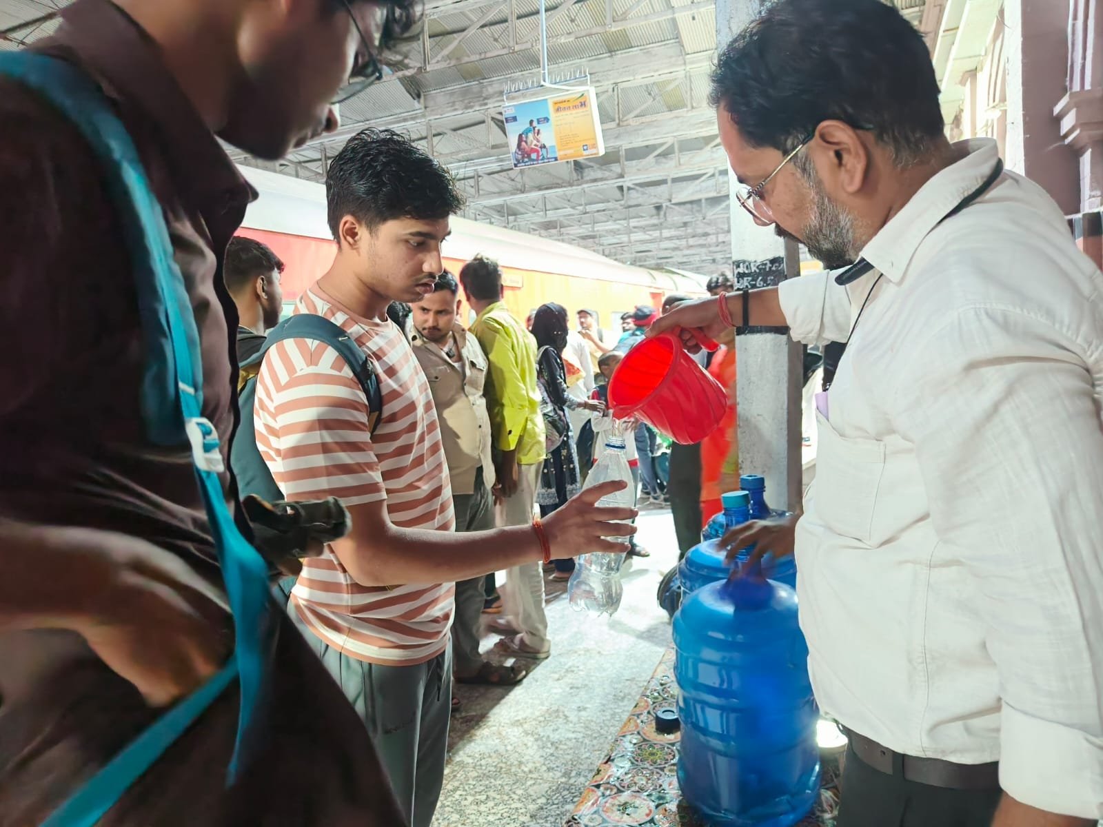 Volunteers distributing free cold drinking water to passengers at Agra Fort Railway Station to provide relief during summer season