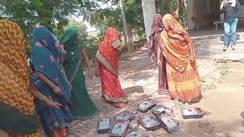 Women carrying removed smart electricity meters to power sub station in Gurja village Fatehabad