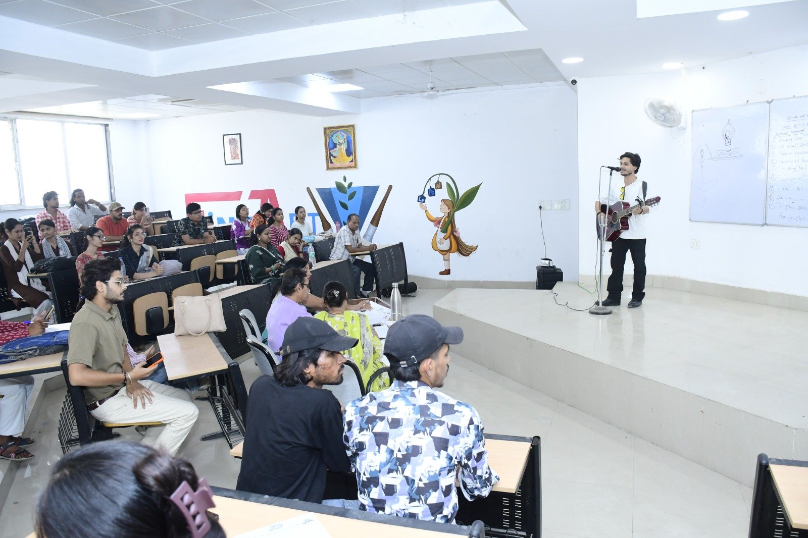 Students performing singing, dancing, acting, and music during the mega audition for the DBRAU centenary celebration in Agra.