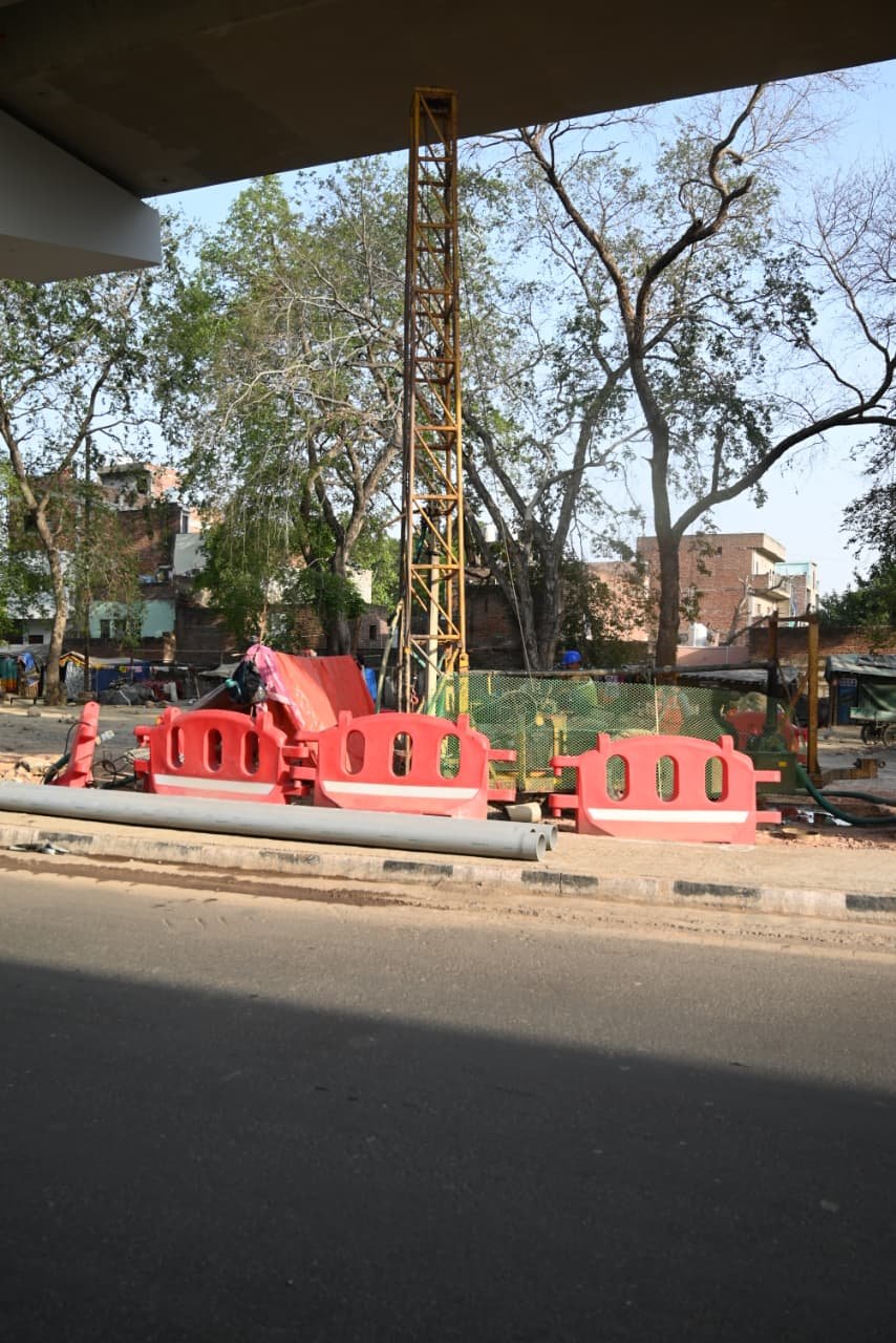 Workers using drilling machines for rainwater harvesting pit construction on Agra Metro first corridor elevated section