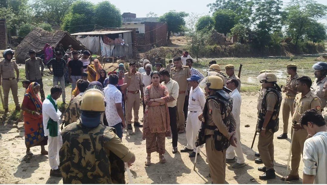 Administrative team clearing waterlogged streets in Charrpura village using a bulldozer to prevent disease outbreaks and improve drainage.