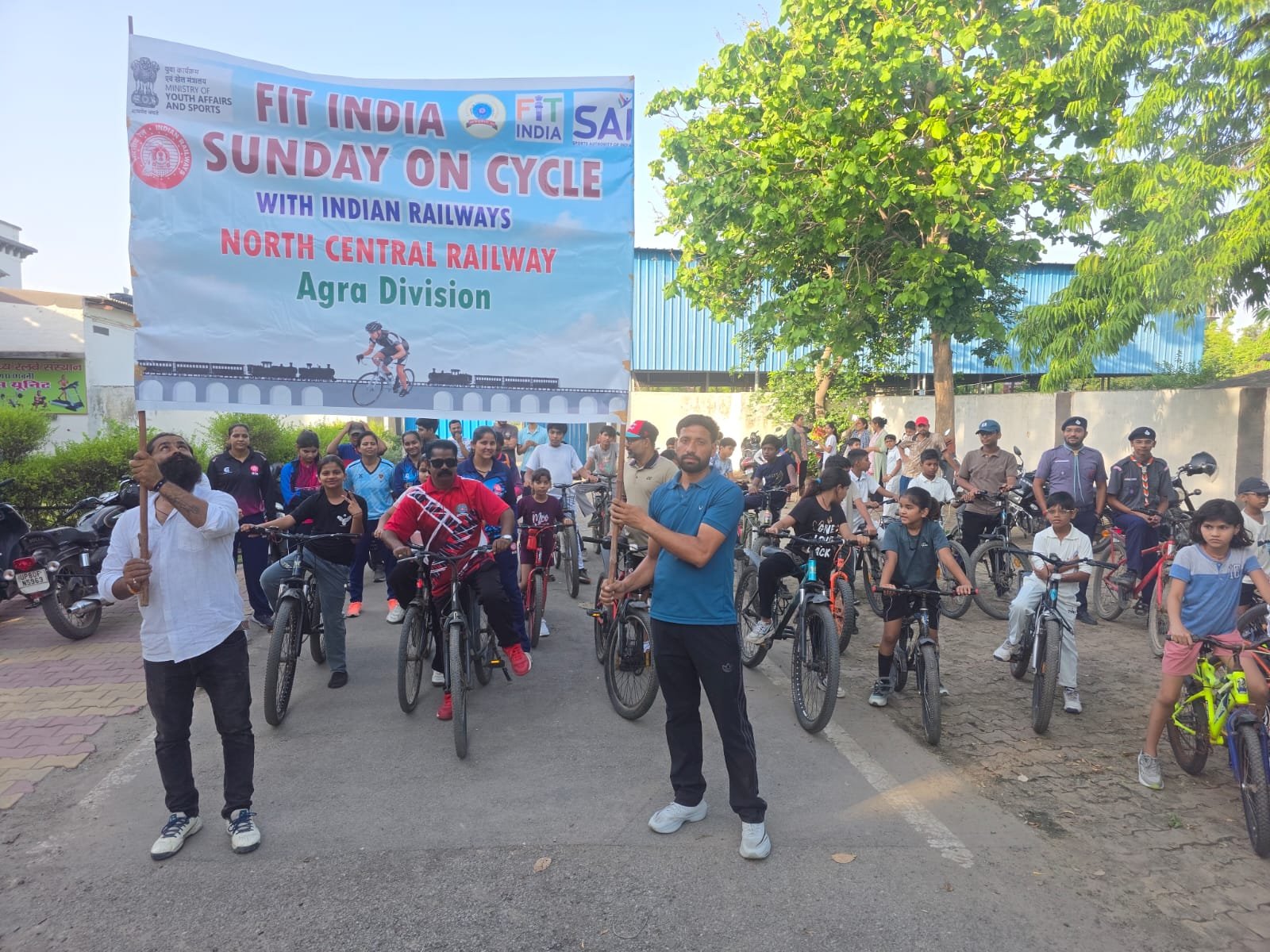 Railway employees and children participating in the Fit India Cycle Drive at Govardhan Stadium in Agra.