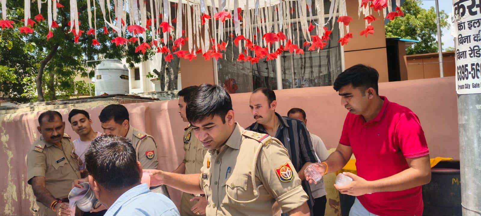 Dauki Police officers distributing sherbet to passersby on Nirjala Ekadashi in Fatehabad, Agra.