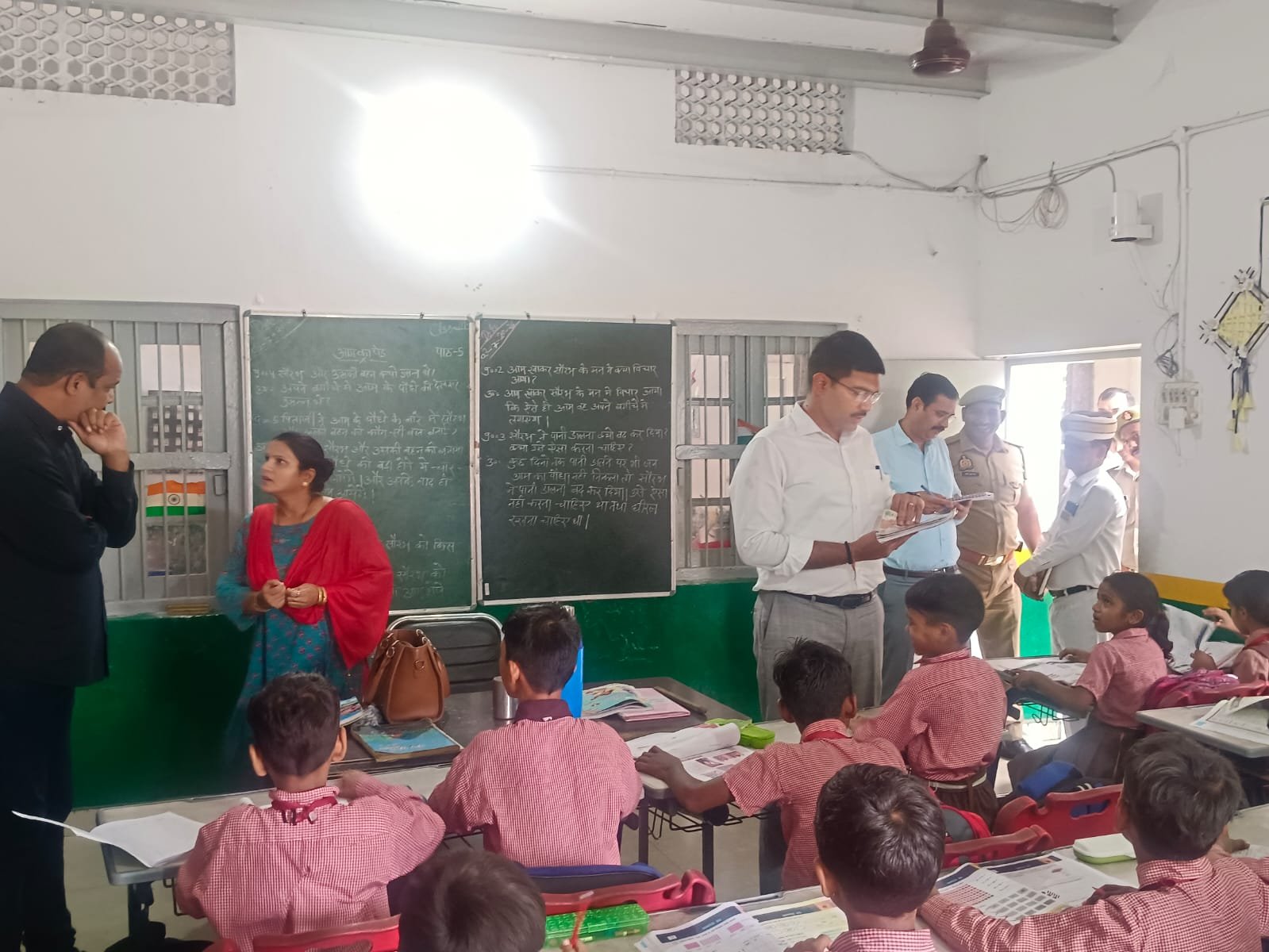 Agra District Magistrate Manish Bansal interacting with students during a surprise inspection at PM SHRI School and Primary School, checking classrooms, teaching quality, and Mid-Day Meal arrangements.