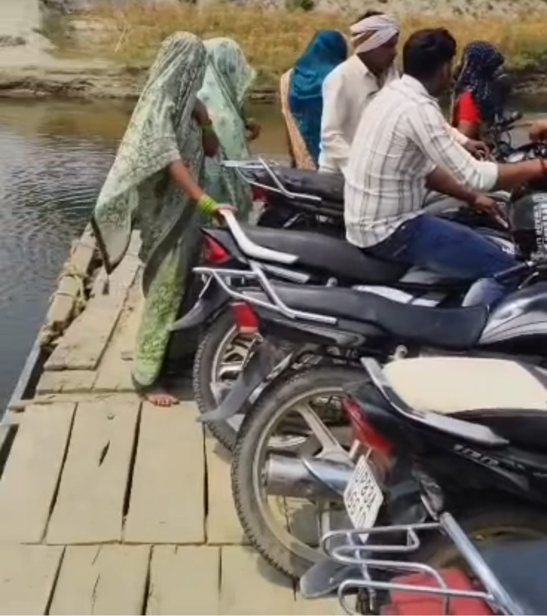 A private boat carrying passengers and motorcycles across the Yamuna River at Paroli Sikarwar Ghat in Fatehabad, Agra.