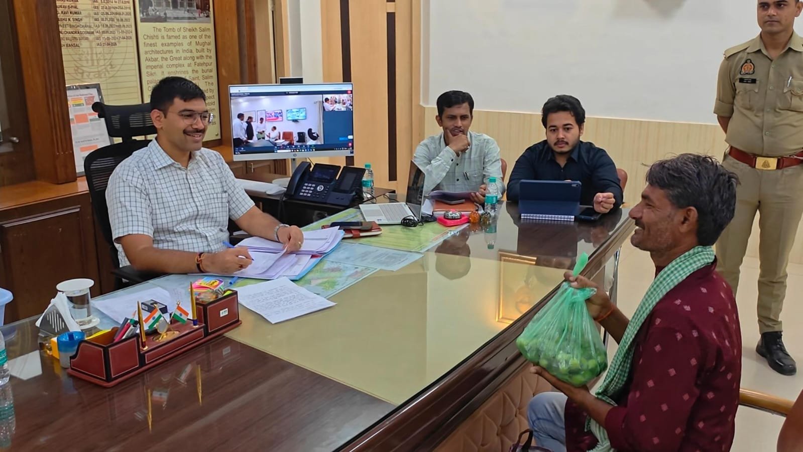 Farmer presenting wild kakora to Agra District Magistrate Manish Bansal as a gesture of gratitude after his long-pending land measurement issue was resolved.