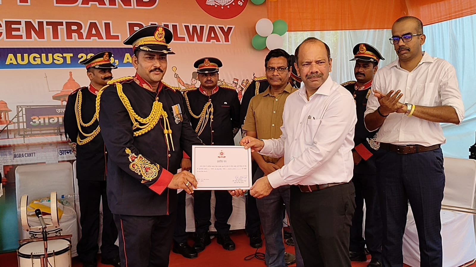 DRM Gagan Goyal receiving a certificate of appreciation from the RPF Band Team at Agra Cantt Railway Station