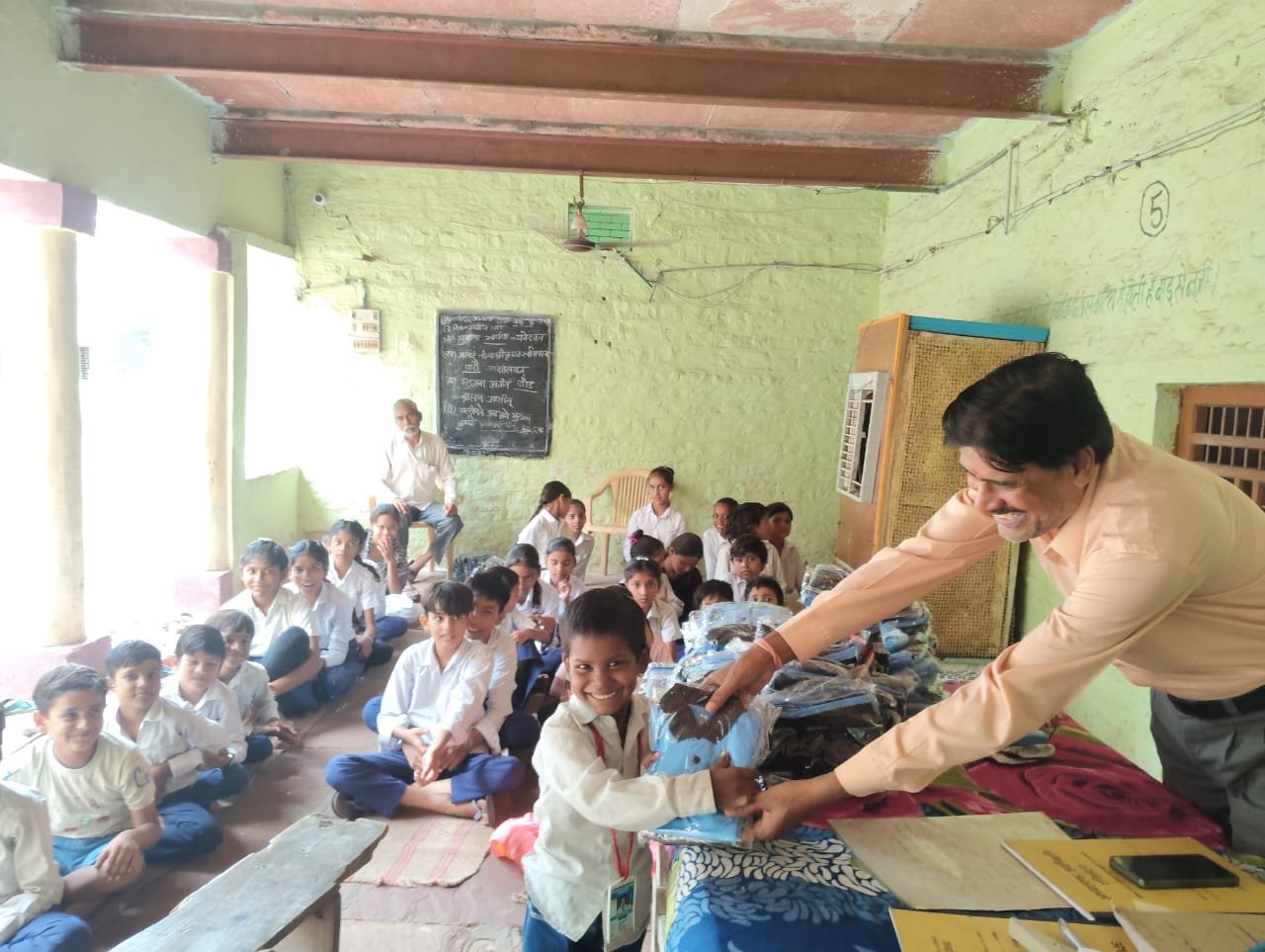 School management distributing free uniforms to students