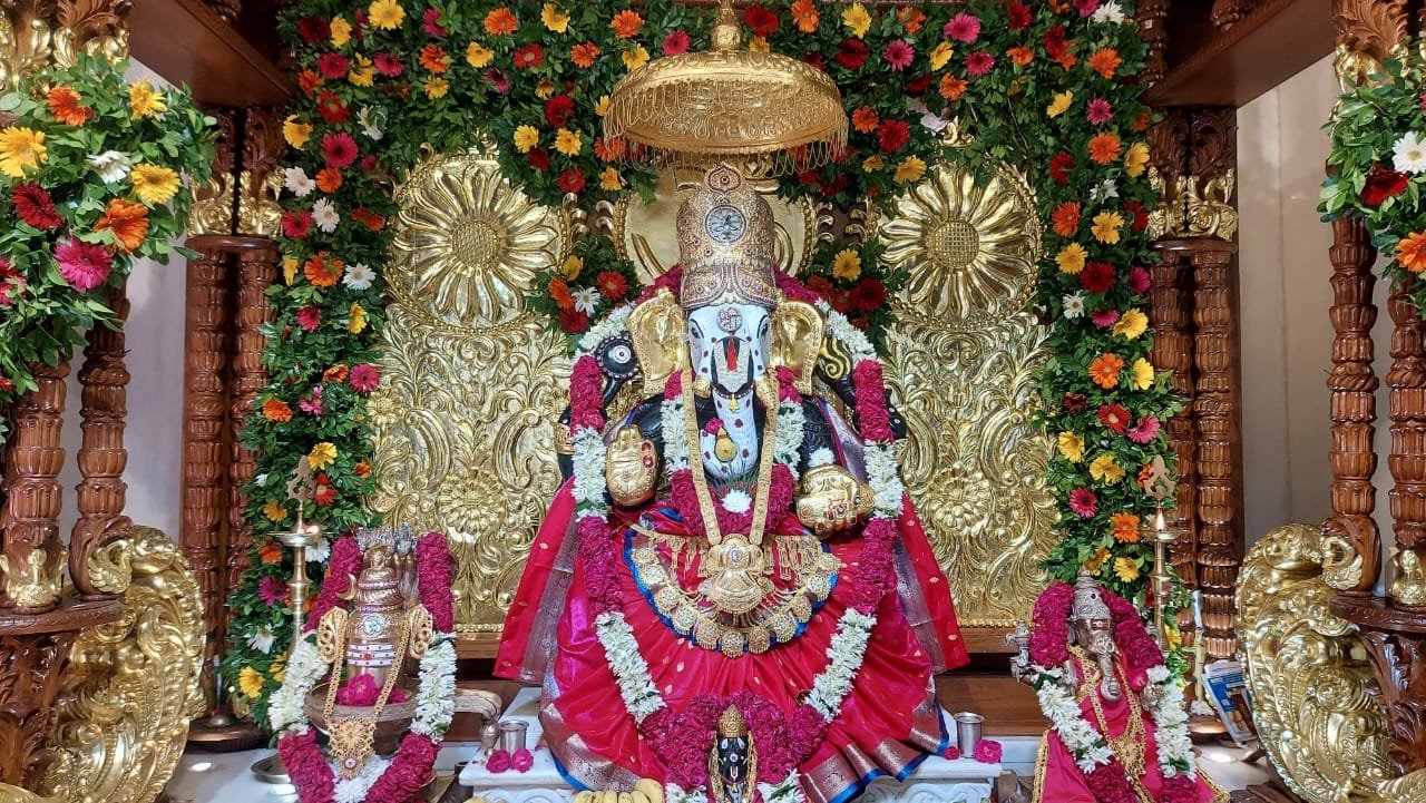 Mahaganpati adorned in Karpur Gauram form with red attire and gold ornaments during Ganesh Mahotsav