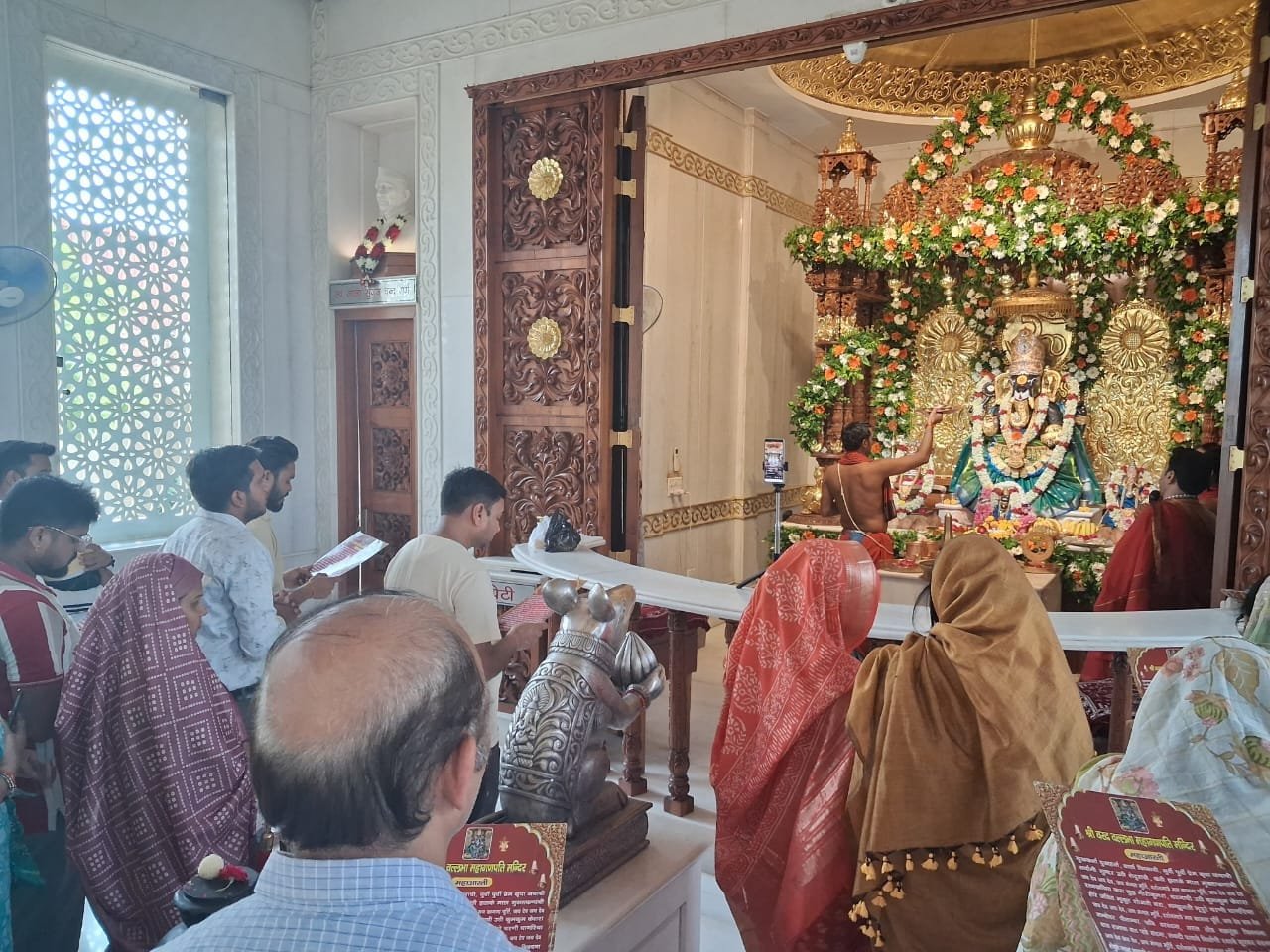 Mahaganpati adorned in blue dress with golden crown, ornaments and kesar Surya tilak during Ganesh Mahotsav
