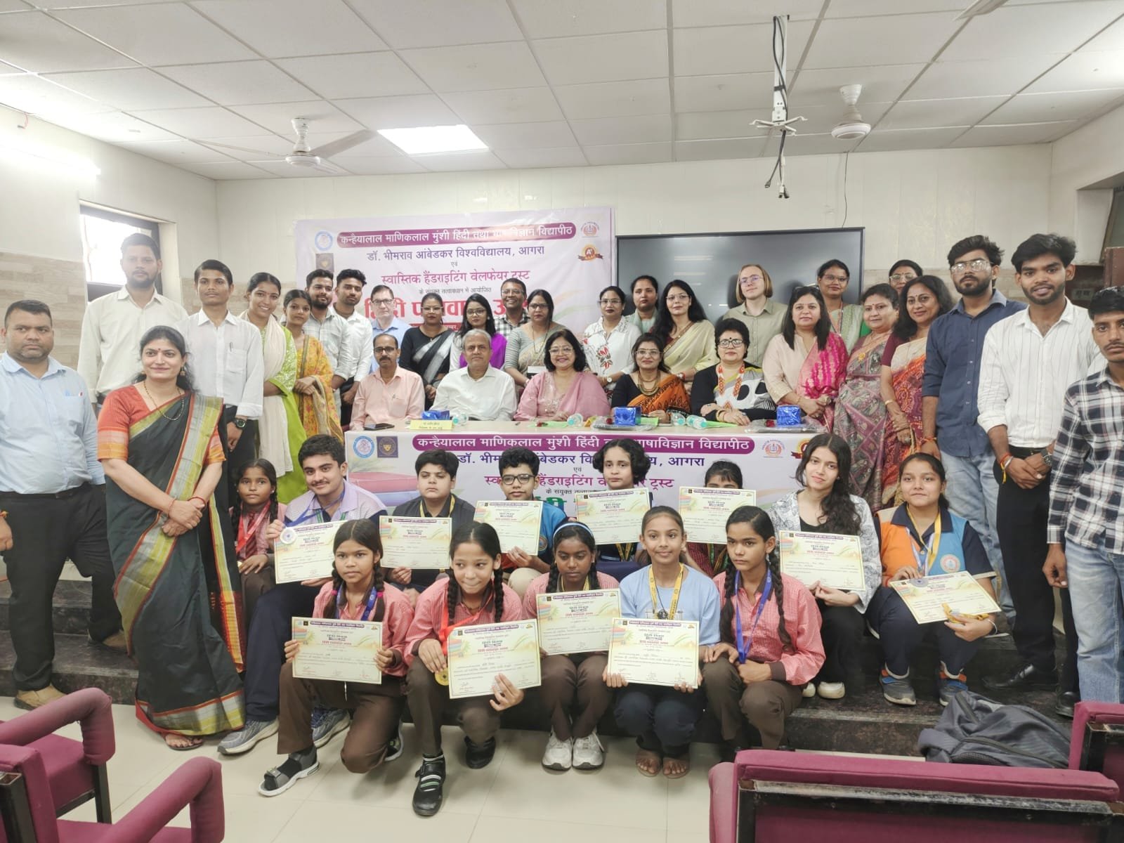 Students receiving medals and certificates at the Hindi Pakhwada closing ceremony