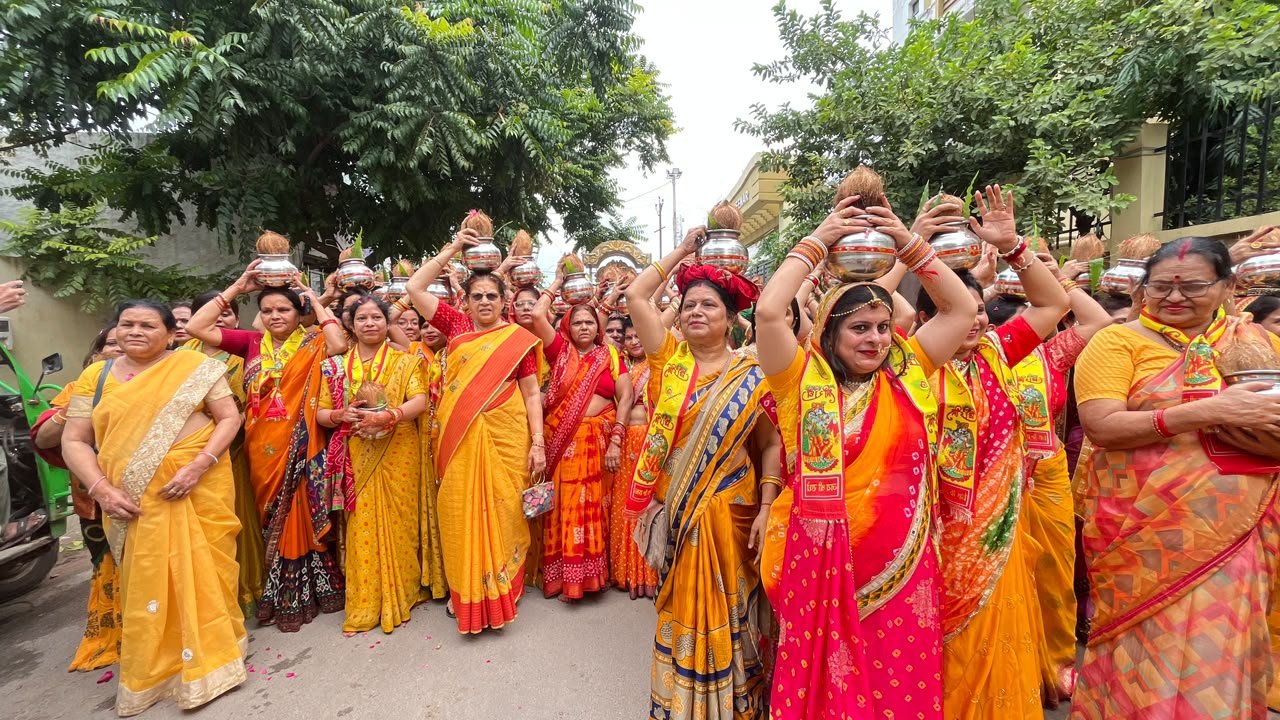 Women in yellow attire carrying sacred kalash during Bhagwat Katha Kalash Yatra in West Puri and Shastripuram