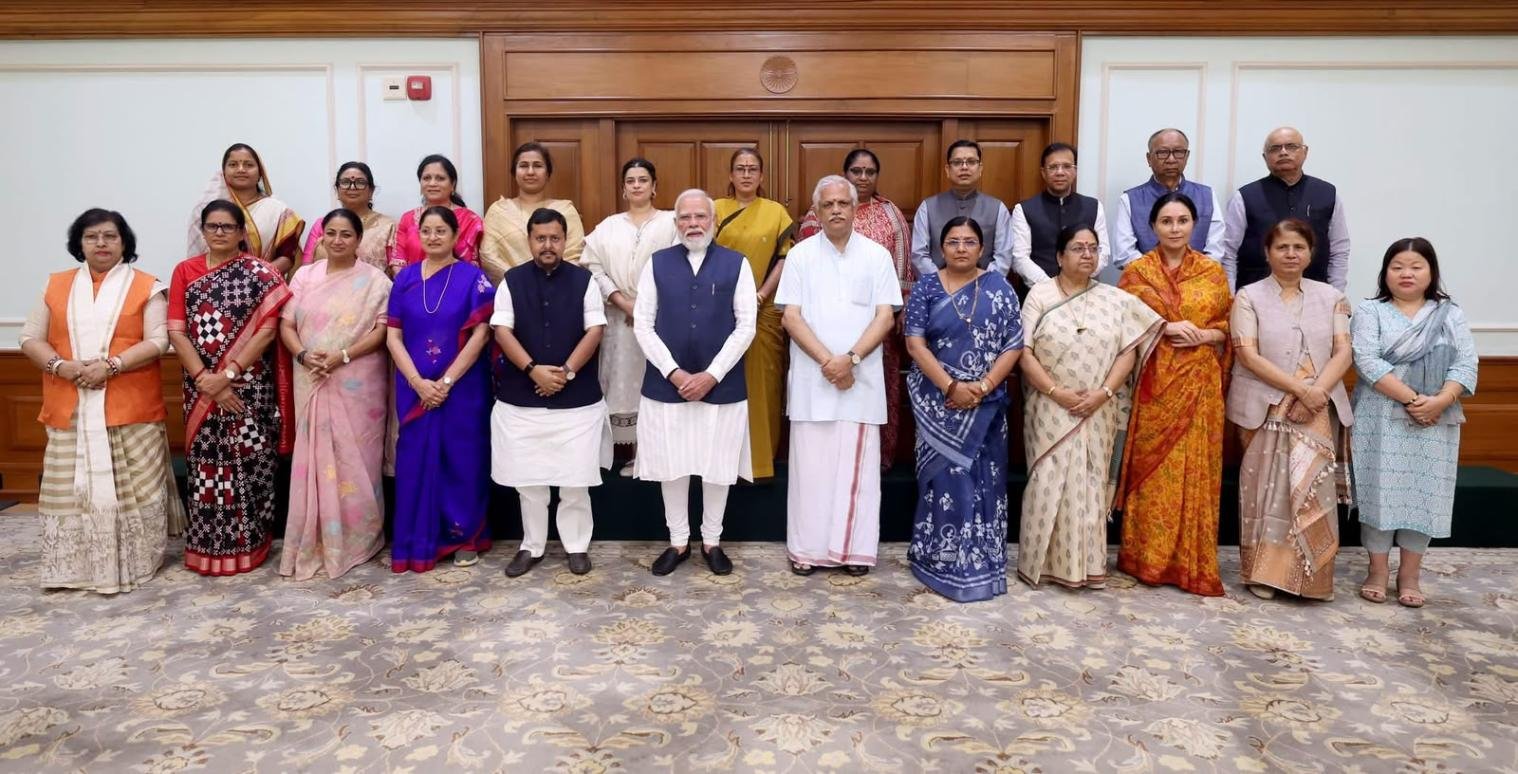 Prime Minister Narendra Modi standing with women during a women empowerment-related event.